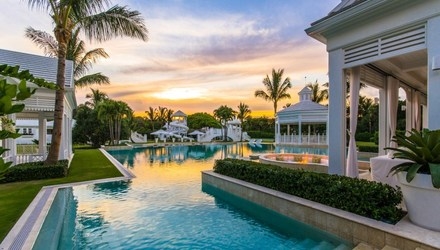 Wide blue pool and the interesting white pool house near it